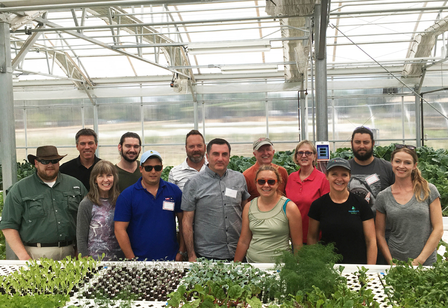Our instructors and ten students touring an indoor aquaponic greenhouse in Denver.