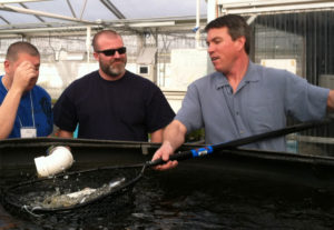 JD Sawyer co-owner of The Aquaponic Source giving students a hands on demonstration on catching fish.
